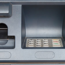 Close up of an ATM machine showing screen and keypad