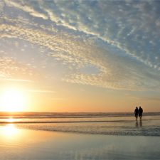 Couple walking on the beach at sunset