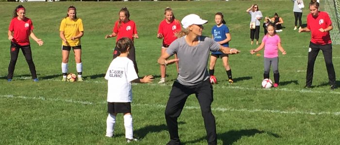 Olympic Gold Medalist Kristine Lilly teaches children on the soccer field.