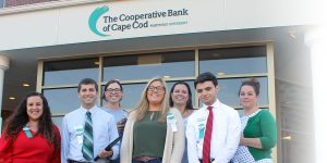 6 branch employees, part of the Bank's Tech Ambassador program, stand in front of The Coop's Admin & Operations Center