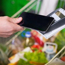Mobile phone being used for paying for a cart of groceries
