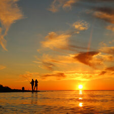 two silhouettes fishing in the sunset