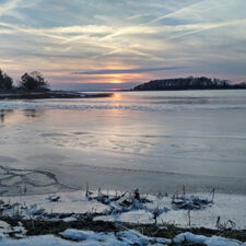 Image of frozen bay in Pocasset at sunset.