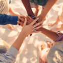 Hands of young people on stack at beach