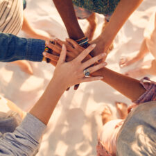 Hands of young people on stack at beach